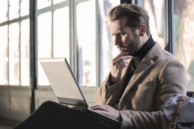 confused man using a laptop 