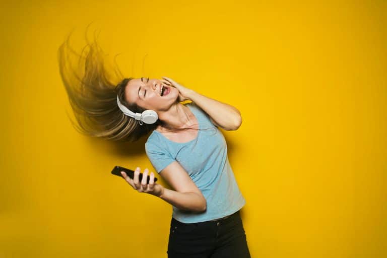 woman waving her hair in the air while listening to music through headphones