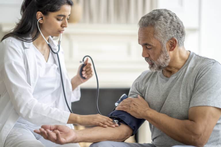 Doctor checking a man's blood pressure.